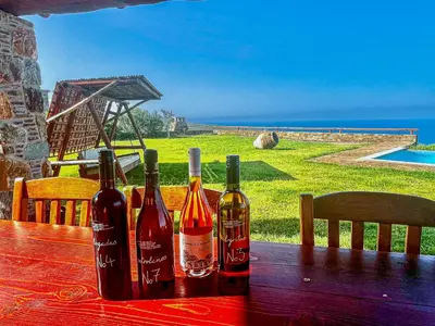 three bottles of wine sitting on a wooden table at VILLA DEMETRA in Kissamos
