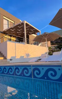 a swimming pool in front of a house with an umbrella at What a View Villa - Amazing Sea & Sunset Panorama with Pool in Chania Town