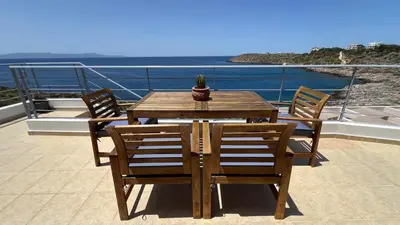 a wooden table and chairs with a cactus on a balcony at What a View Villa - Amazing Sea & Sunset Panorama with Pool in Chania Town