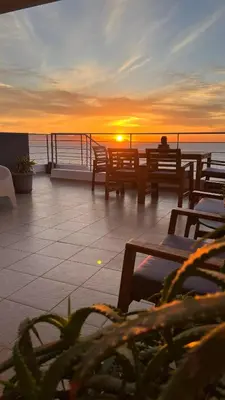 a person sitting on a deck watching the sunset at What a View Villa - Amazing Sea & Sunset Panorama with Pool in Chania Town
