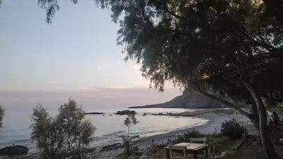a beach with a picnic table and a view of the ocean at Georgoshouse Lykos beach Sfakia in Livanianá