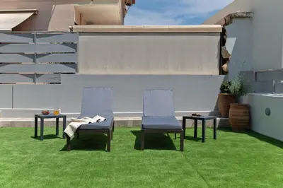 two chairs sitting on a yard with grass at Peggy's house by 8essentially in Chania Town