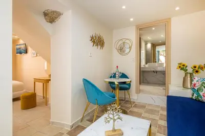 a living room with a blue chair and a table at Ydragogeio Rooms Old Town in Chania Town