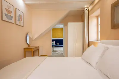 a bedroom with a large white bed and a staircase at Ydragogeio Rooms Old Town in Chania Town