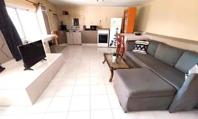 a living room with a couch and a kitchen at Village house with a nice garden in Stérnai