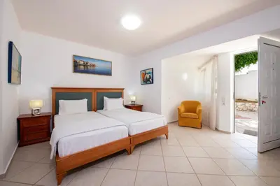 a bedroom with a large bed and a chair at Luxury Seaside Villa Plumeria ,50m to Sandy Beach, Chania in Tersanas
