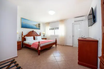 a bedroom with a bed and a flat screen tv at Luxury Seaside Villa Plumeria ,50m to Sandy Beach, Chania in Tersanas