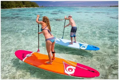 two people are standing on surfboards in the water at Luxury Seaside Villa Plumeria ,50m to Sandy Beach, Chania in Tersanas
