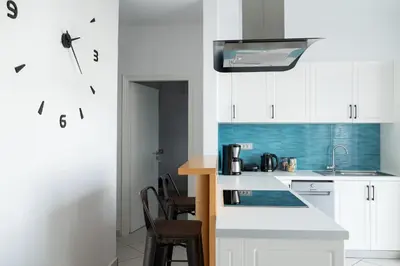 a kitchen with white cabinets and a counter top at The Teacher's Home 2 minutes away from the beach in Galatás