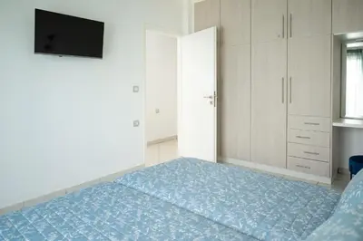 a bedroom with a bed and a tv on the wall at The Teacher's Home 2 minutes away from the beach in Galatás