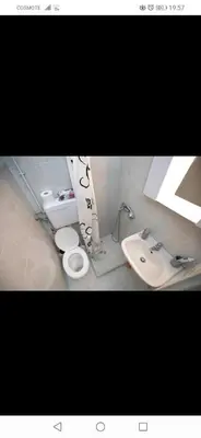 two pictures of a bathroom with two toilets and a sink at central cozy and lovely house in Chania Town