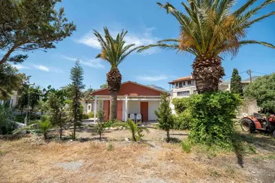 a house with two palm trees in front of it at Milos Alexandra Studio in Frangokastello