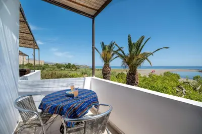 a table and chairs on a balcony with a view of the ocean at Milos Alexandra Studio in Frangokastello