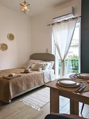 a bedroom with a bed and a table and a window at Cozy Apartment in Chania Town
