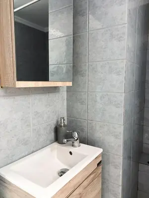 a bathroom with a white sink and a mirror at Cozy Apartment in Chania Town