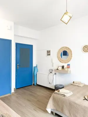 a room with two beds and a blue door at Cozy Apartment in Chania Town