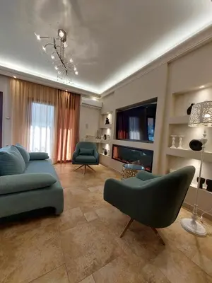 a living room with a couch and chairs and a television at Rika's Sea View Apartment in Chania Town
