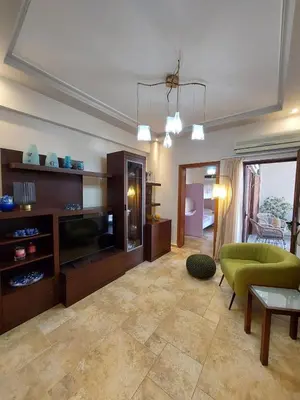 a living room with a couch and a television at Rika's Sea View Apartment in Chania Town