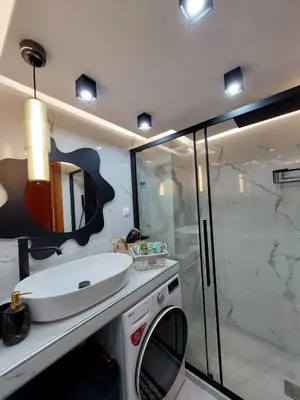 a bathroom with a white sink and a shower at Rika's Sea View Apartment in Chania Town