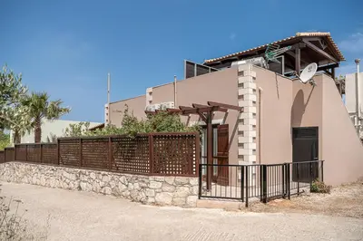 a house with a gate and a fence at La Torre Villa in Palio Gerani