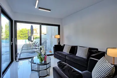 a living room with a black couch and a table at Casa Cafenio by PosarelliVillas in Nípos
