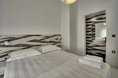 a white bedroom with a large bed and a mirror at Casa Cafenio by PosarelliVillas in Nípos