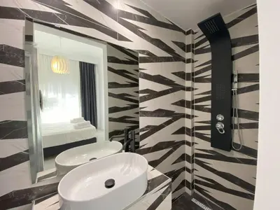 a bathroom with two white sinks and a mirror at Casa Cafenio by PosarelliVillas in Nípos