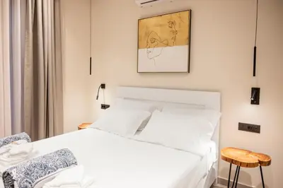 a bedroom with a white bed and a picture on the wall at Falasarna's Dream in Kissamos