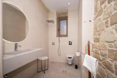 a white bathroom with a sink and a toilet at Falasarna's Dream in Kissamos