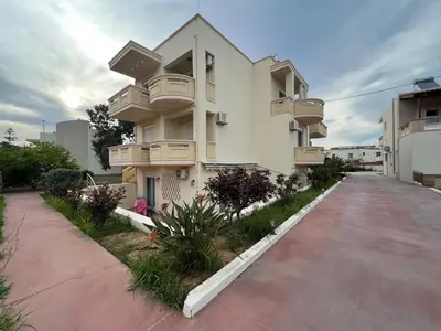 a building with balconies on the side of a road at Seaside cozy apartment in Aghii Apostoli