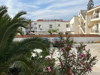 a car parked in a parking lot next to some buildings at Seaside cozy apartment in Aghii Apostoli