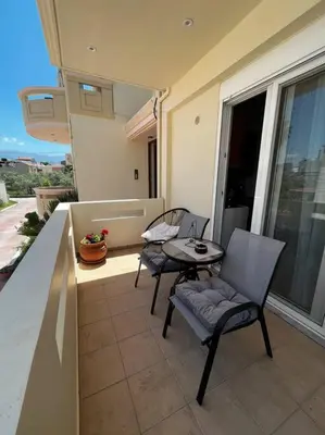 a patio with two chairs and a table on a balcony at Seaside cozy apartment in Aghii Apostoli