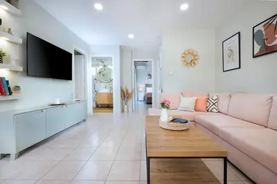 a living room with a pink couch and a table at Gigis Apartment in Chania Town
