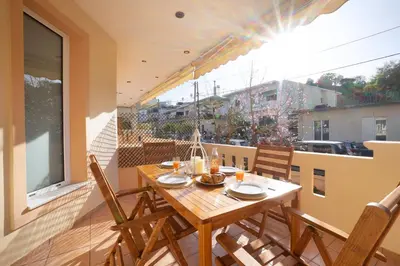 a wooden table and chairs on a balcony at Gigis Apartment in Chania Town