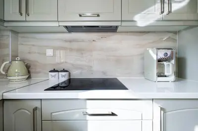 a kitchen with white cabinets and a toaster on a counter at Gigis Apartment in Chania Town