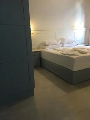 a bed with white sheets and pillows in a bedroom at Hotel Porto Loutro on the Hill in Loutro