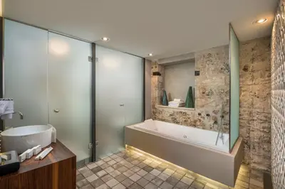 a bathroom with a shower and a tub and a sink at Ambassadors Residence Boutique Hotel in Chania Town