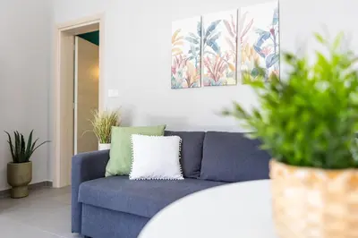 a blue couch in a living room with plants at Fanouris Luxury Apartments in Chania Town