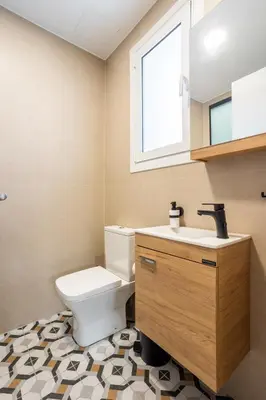 a bathroom with a toilet and a sink and a window at Fanouris Luxury Apartments in Chania Town