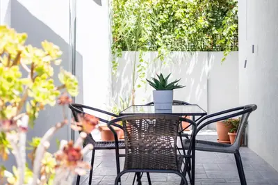 a table and chairs on a patio with plants at Fanouris Luxury Apartments in Chania Town