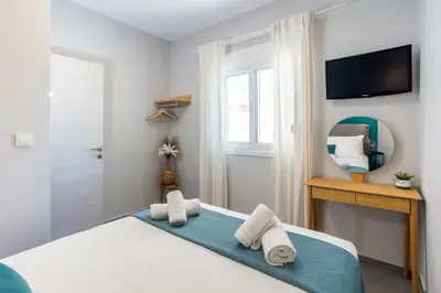 a bedroom with a bed and a mirror and a television at Fanouris Luxury Apartments 2 in Chania Town