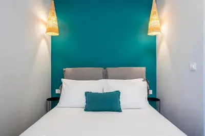 a bed with white pillows and a blue wall at Fanouris Luxury Apartments 2 in Chania Town