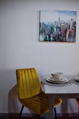 a dining room table with a yellow chair and a painting at Cozy rooms at the old Venetian Harbor, Chania Town in Chania Town