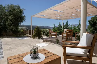 a patio with a white canopy and chairs and a table at Freya's Royal Estate, Kissamos in Khairethianá