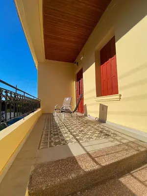 a balcony with two chairs and a red door at THE NEOCLASSICAL Garden House in Chania Town