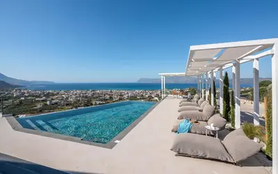 a row of lounge chairs next to a swimming pool at Onar Villa - staying in comfort in Kissamos