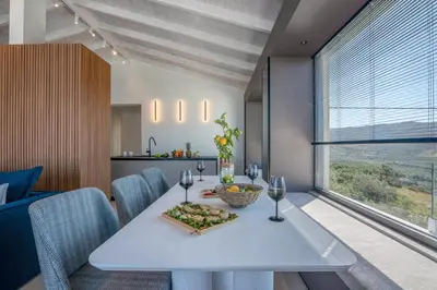 a dining room with a white table with wine glasses at Onar Villa - staying in comfort in Kissamos