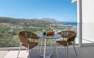a table with fruit and a glass of wine on a balcony at Onar Villa - staying in comfort in Kissamos