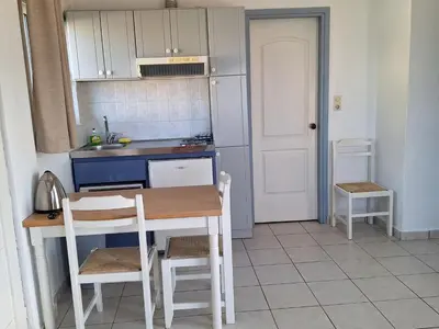 a small kitchen with a table and chairs in it at Artemis Apartments in Kalyves