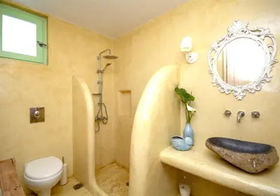 a bathroom with a sink and a toilet and a mirror at NiMa Maison in Kissamos